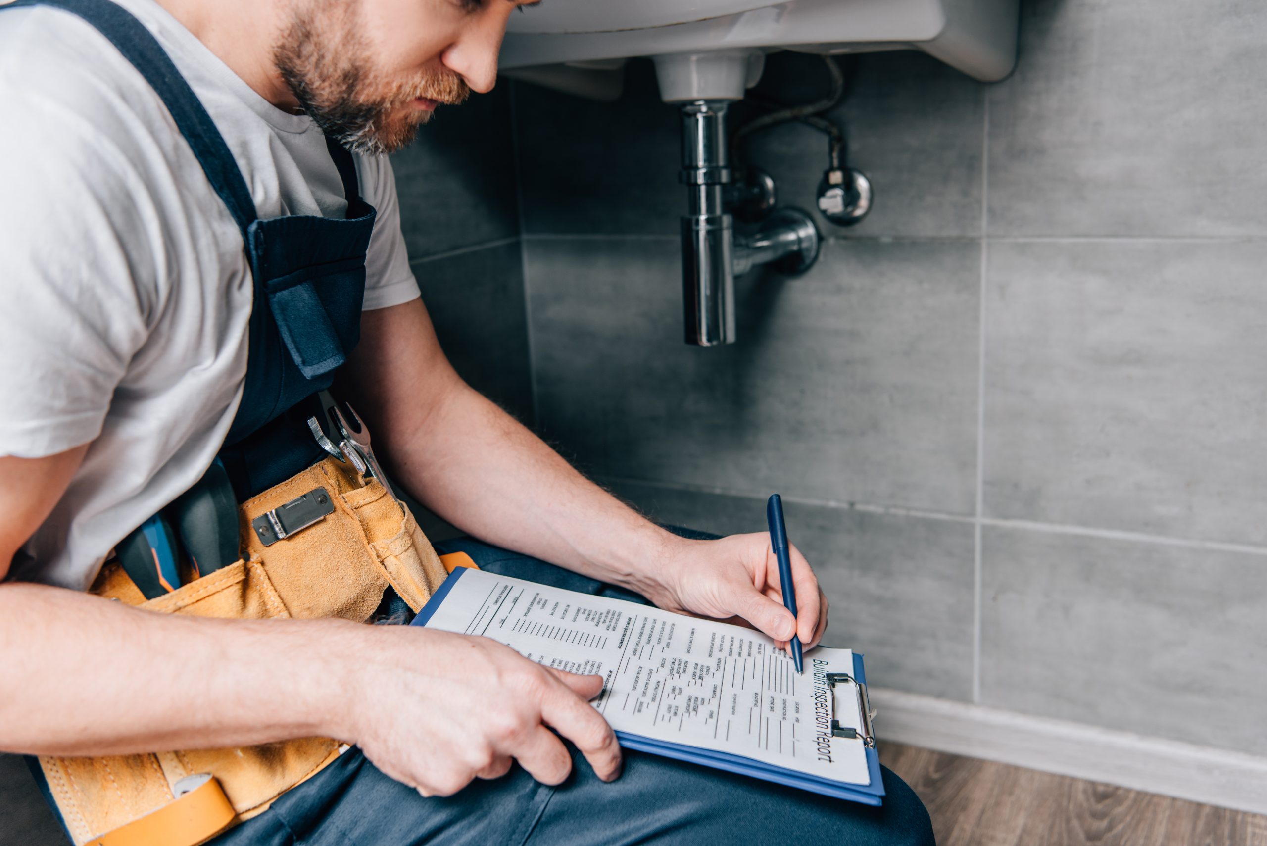 Plumber completing inspection report Plumber completing inspection report