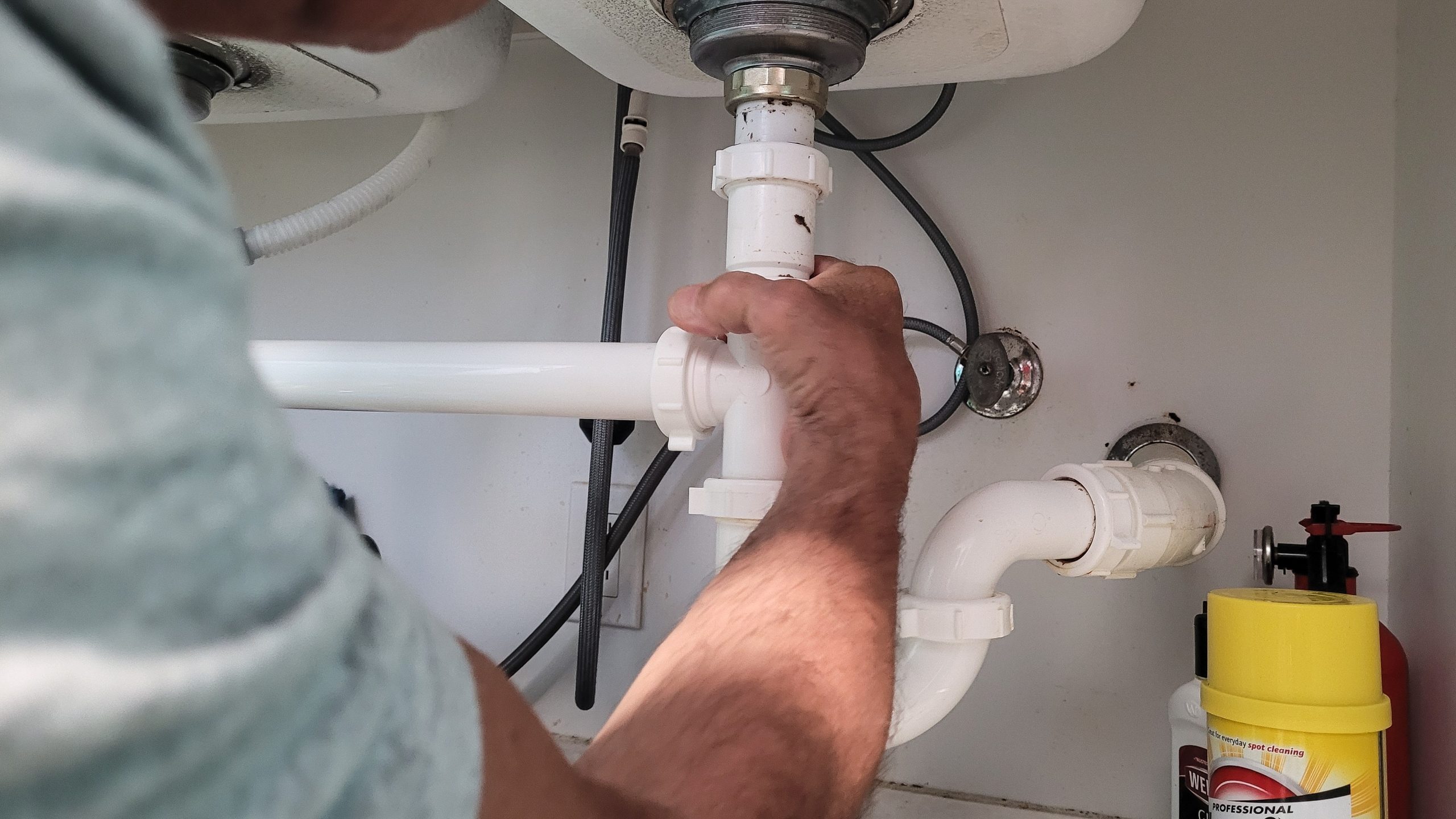 Plumber repairing a leak from sink